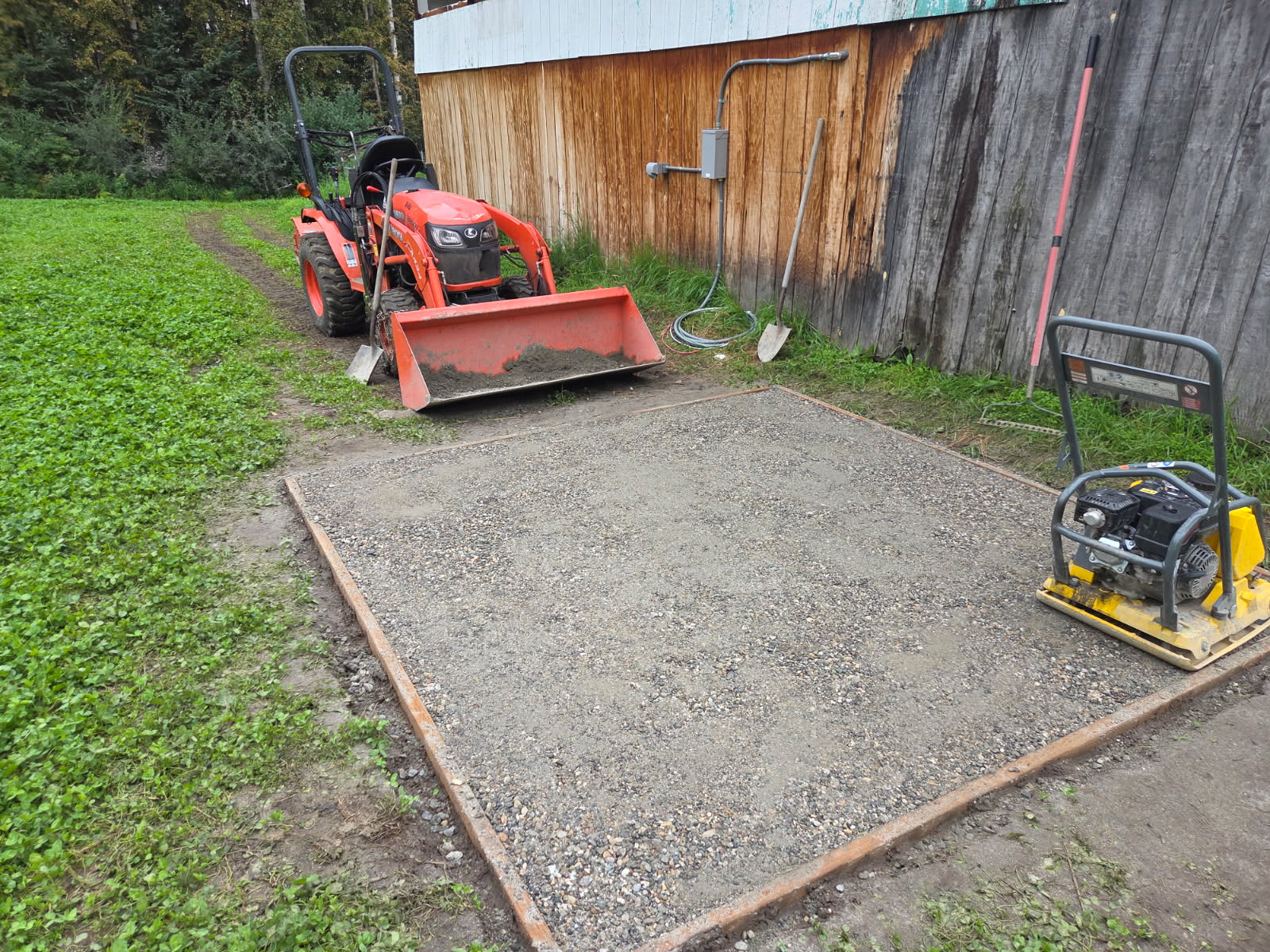 D1 compacted level pad for soon to be delivered hot tub, tractor and compactor nearby, electrical ready to hook up in background